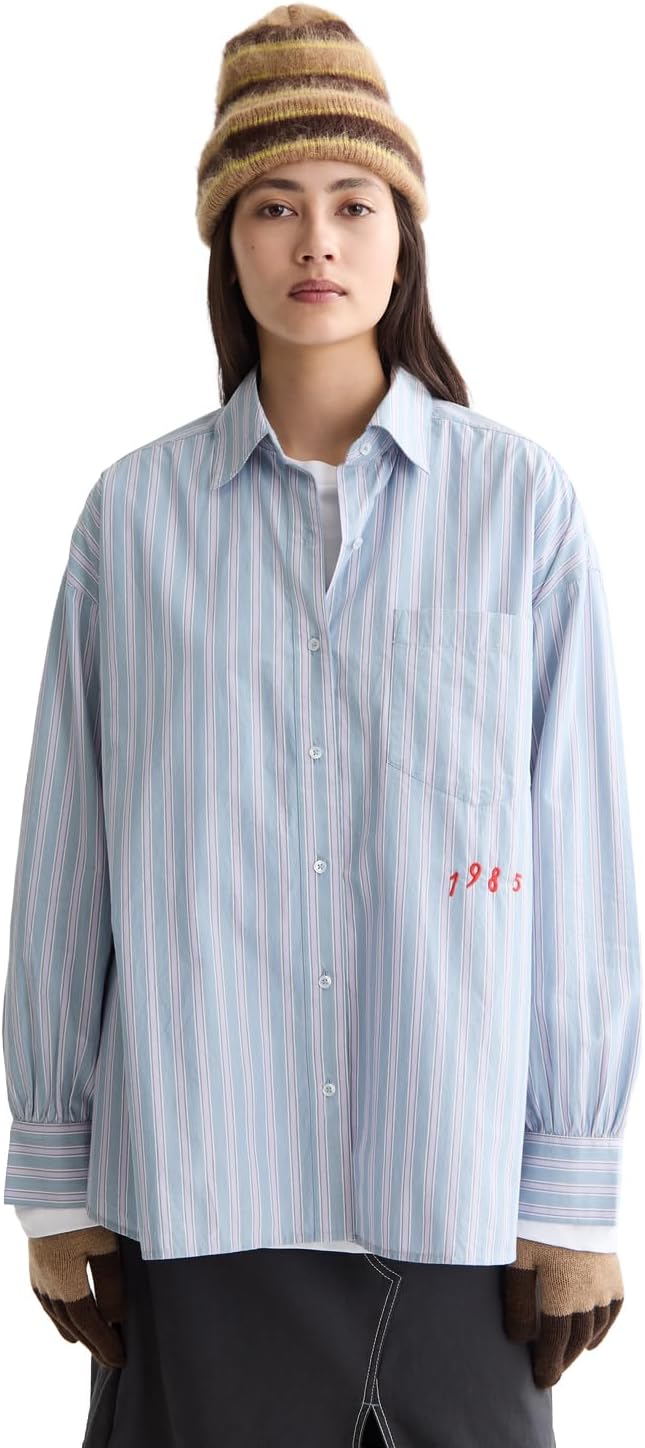 Donna che indossa la camicia Mamiye Brothers in denim lavanda stripe in un ambiente casual
